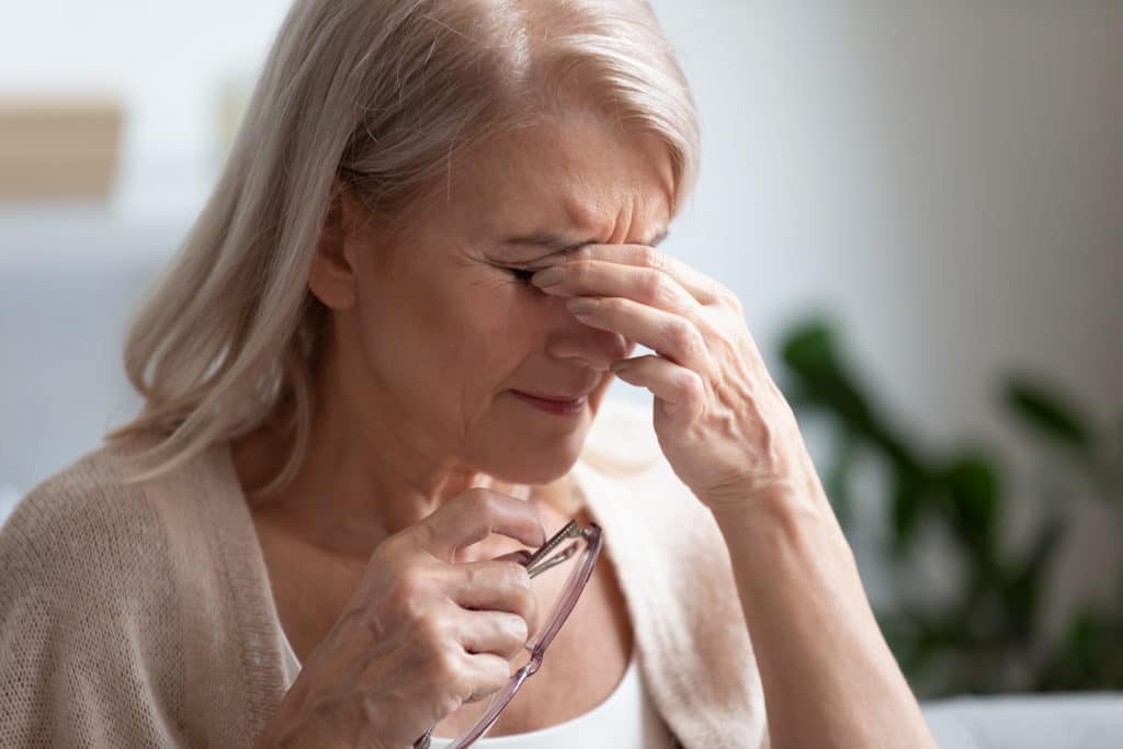 Woman rubbing itchy, painful eyes