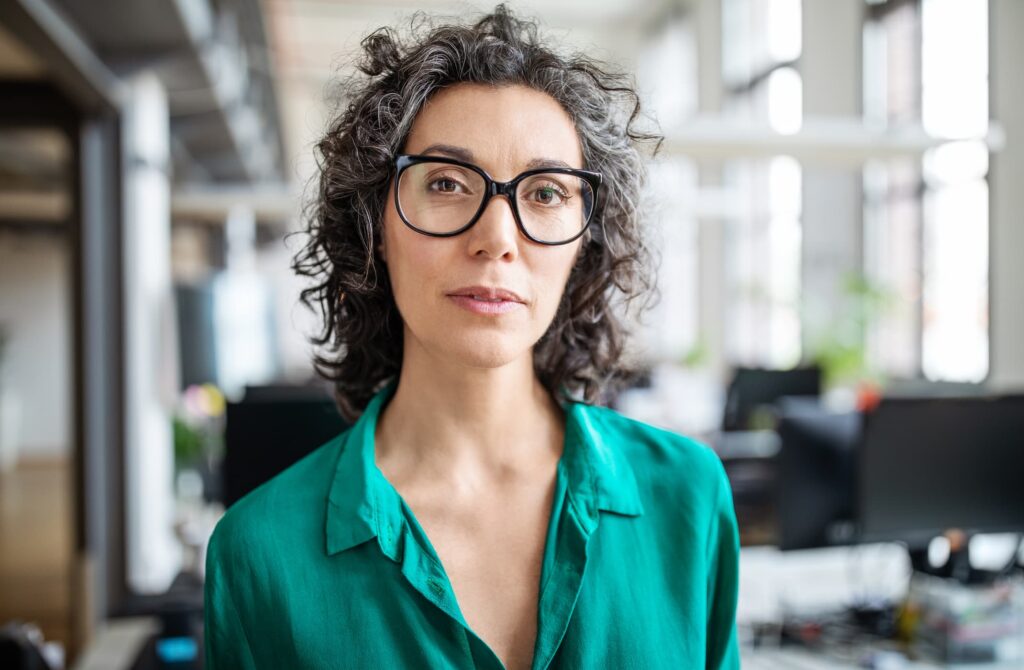Portrait of mature businesswoman in casuals standing in office. Close-up of confident female entrepreneur looking at camera.