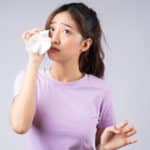 Young Asian woman wipes her tears with a tissue