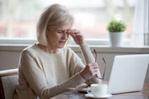 senior mature business woman taking off glasses tired of computer work