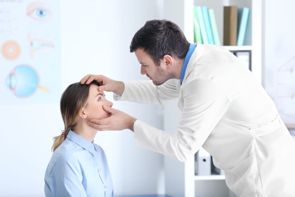 An ophthalmologist examining a woman’s eyes to diagnose uveitis.