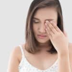 A woman covering her eye after orbital trauma in Stockton, CA