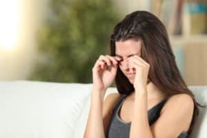 A woman with ectropion and skin disorders rubbing her eyes