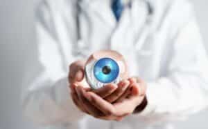 An ophthalmologist holding a model of an eye