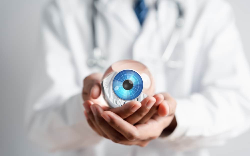 An ophthalmologist holding a model of an eye