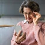 A woman with cataracts looking at her phone