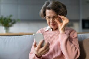 A woman with cataracts looking at her phone