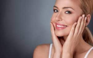 A woman touching her cheeks after Lumenis M22 skin resurfacing in Stockton, CA