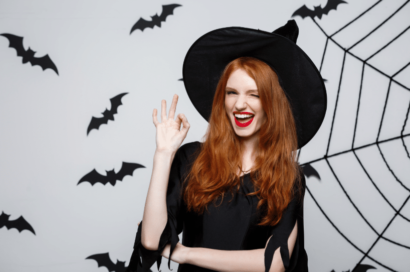 A woman dressed as a witch winking at the camera