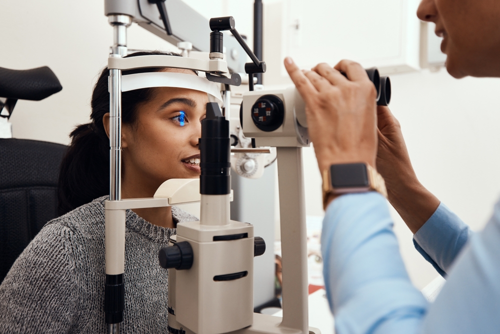 Young woman getting a routine eye exam to monitor possible eye conditions and prevent eye disease.